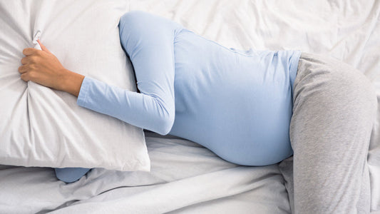 A pregnant woman sleeping peacefully in bed, representing an article on natural sleep solutions during pregnancy.
