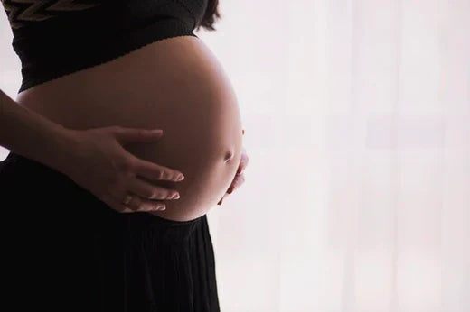 A close-up of a woman's pregnant belly, symbolizing an article about natural pain relief and easing birth.