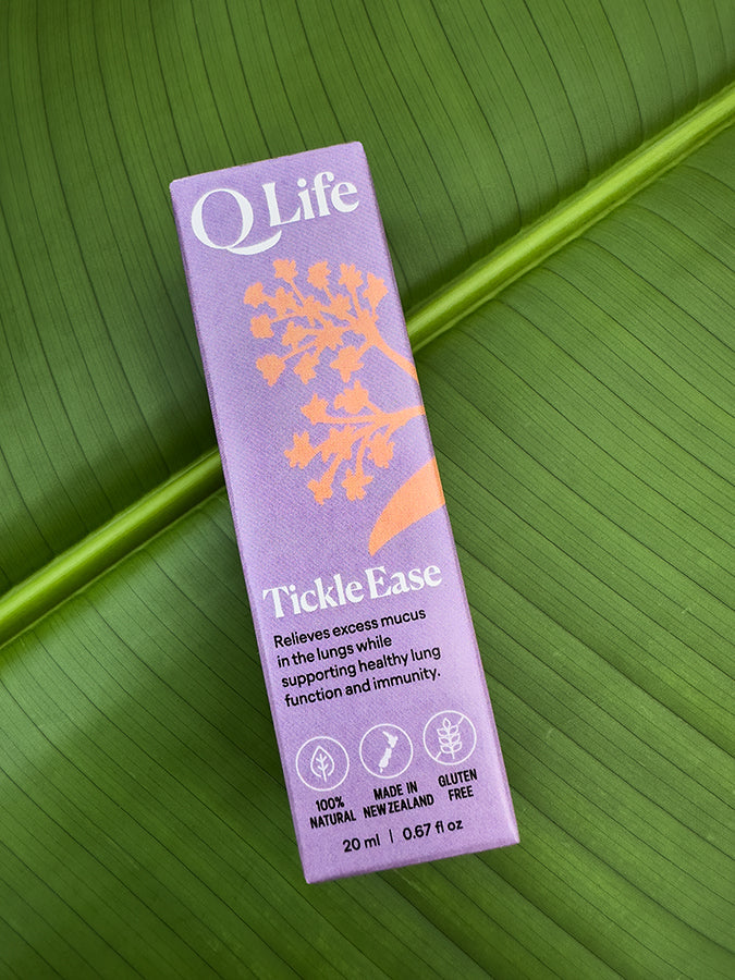 Q Life Tickle Ease box on a green leaf, highlighting the product's natural ingredients.