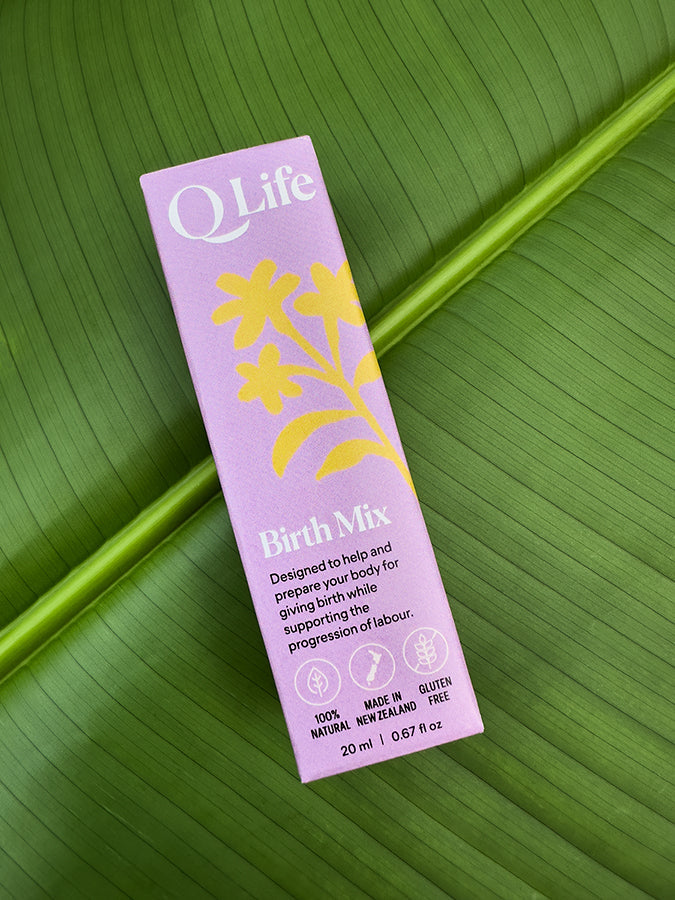 Q Life Birth Mix box on a green leaf, highlighting the product's natural ingredients.