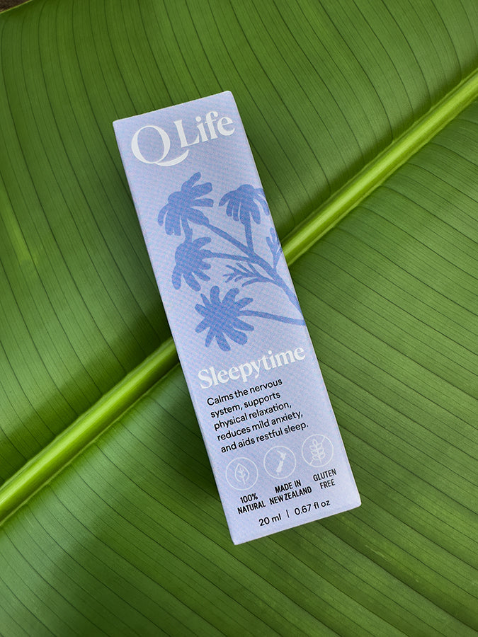 Q Life Sleepytime box on a green leaf, highlighting the product's natural ingredients.