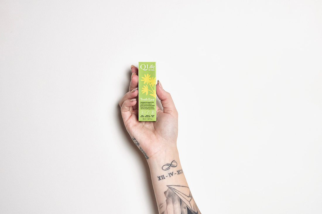 Hand holding a bottle of QLife Teeth Ease Drops